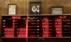 FILE - Various rates and prices for currencies and gold coins are displayed at an exchange bureau, in Tehran, Iran, Aug. 21, 2019.