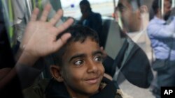 FILE - A Yemeni boy waves from inside a bus before boarding a U.N. plane at Sanaa's airport, Yemen, Feb. 3, 2020. The U.N. medical relief flight was the first in over three years. Another left Feb. 8.