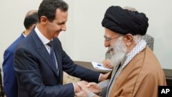 In this photo released by the Syrian official news agency SANA, Syrian President Bashar al-Assad, left, shakes hands with Iranian Supreme Leader Ayatollah Ali Khamenei, before their meeting in Tehran, Syria, Feb. 25, 2019. 