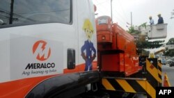 Electricians from the Manila Electric Railroad And Light Company (MERALCO) work on a transmission line in Manila on Aug. 11, 2015. 