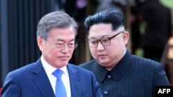 Le président sud-coréen Moon Jae-in et le dirigeant nord-coréen Kim Jong Un marchent lors du sommet historique au village de Panmunjom, le 27 avril 2018.