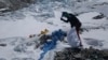 ARCHIVO - Esta imagen proporcionada por Peak Promotion muestra a un miembro del equipo financiado por el gobierno de Nepal valiéndose de un pico para retirar basura congelada en camino al monte Everest, el martes 27 de abril de 2021, en Nepal.