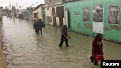 Ljudi hodaju poplavljenim ulicama u četvrti glavnog grada Haitija Port-o-Prensa