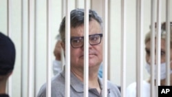 FILE - Viktar Babaryka, a former presidential hopeful, stands inside a defendants’ cage during his trial in Minsk, Belarus, on July 6, 2021. 