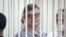 FILE - Viktar Babaryka, a former presidential hopeful, stands inside a defendants’ cage during his trial in Minsk, Belarus, on July 6, 2021. 