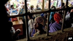 A Congolese woman refugee sits with others at the Nkamira transit center for refugees in western Rwanda Saturday, May 5, 2012. 