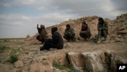 Para pejuang SDF (Pasukan Suriah yang dibantu AS) di atas bukit di dekat kota Baghouz, Suriah, 14 Februari 2019. (Foto: dok).