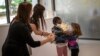 Teachers try to prevent the hug between Wendy Otin, 6, and Oumou Salam Niang, 6, as they meet on the first day of school after the lockdown, at a primary school in Barcelona, Spain.