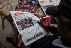 FILE - A man reads The Reporter newspaper, with the cover showing the Peace Nobel Prize ceremony for Ethiopia’s Prime Minister Abiy Ahmed, in Addis Ababa, Dec. 11, 2019.