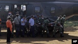 Indonesian soldiers carry a victim of Wednesday's plane crash at Cijeruk in Bogor, West Java, Indonesia, Saturday, May 12, 2012.