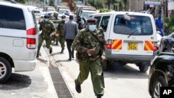 Un policier kenyan tenant une bombe lacrymogène a couru lors de manifestations à Nairobi, au Kenya, le jeudi 13 mai 2021.