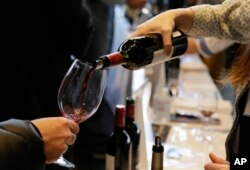 FILE - Adeline Maillard pours a 2015 vintage wine from Chateau Giscours during the Union des Grand Crus of Bordeaux tasting event Thursday, January 25, 2018, in San Francisco.