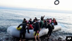 FILE - Migrants arrive at the village of Skala Sikaminias, on the Greek island of Lesbos, after crossing on a dinghy the Aegean sea from Turkey, March 2, 2020.