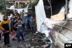 FILE —Children check the damage of a makeshift shelter in a camp set up by displaced Palestinians near the Emirati hospital in Rafah in the southern Gaza Strip, in which several people were reported killed when it was hit by Israeli bombing on March 2, 2024.