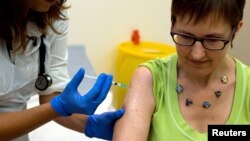 Volunteer Ruth Atkins receives an injection of the Ebola vaccine in Oxford, southern England, Sept. 17, 2014. British drug company GlaxoSmithKline is one of several rushing to create an Ebola vaccine.