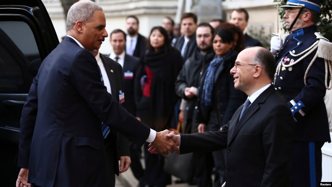 Jaksa Agung AS, Eric Holder (kiri) disambut oleh Mendagri Perancis, Bernard Cazeneuve di Paris (11/1). Holder mengumumkan bahwa AS akan menyelenggarakan KTT anti-teror pada 18 Februari mendatang.