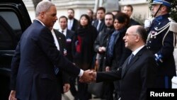 Jaksa Agung AS, Eric Holder (kiri) disambut oleh Mendagri Perancis, Bernard Cazeneuve di Paris (11/1). Holder mengumumkan bahwa AS akan menyelenggarakan KTT anti-teror pada 18 Februari mendatang.