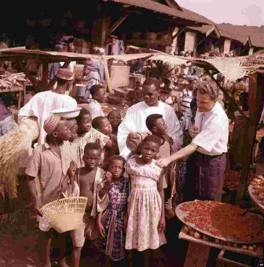 Billy Graham est pris en photo avec des enfants lors d'une visite dans un village, au Ghana, en janvier 1960.