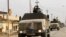 Peshmerga forces ride on military vehicles in the town of Bashiqa, after it was recaptured from the Islamic State, east of Mosul, Iraq, Nov. 9, 2016.