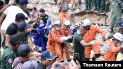 A rescue team carries a wounded worker at a collapsed building in Sihanoukville, Cambodia, June 22, 2019. 