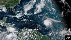 This satellite image provided by the National Oceanic and Atmospheric Administration shows Hurricane Sam, center right, in the Atlantic Ocean, Monday, Sept. 27, 202