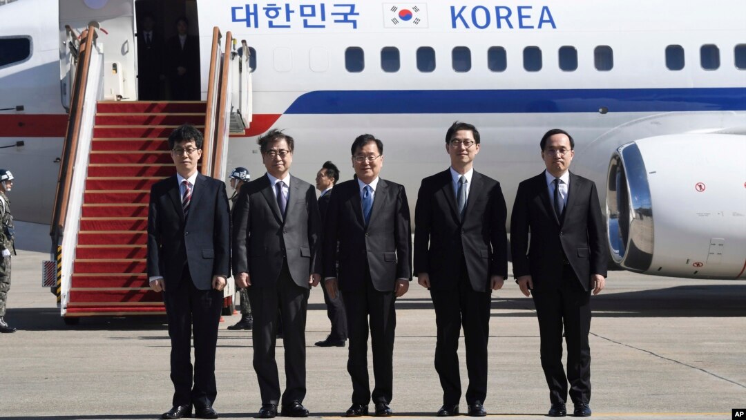 Direktur keamanan nasional Korea Selatan, Chung Eui-yong (tengah), kepala dinas intelijen nasional Suh Hoon (kedua kiri), dan para delegasi lainnya berpose sebelum menaiki pesawat yang akan membawa mereka bertolak ke Pyongyang di bandara militer Seongnam, selatan Seoul, Senin, 5 Maret. , 2018.