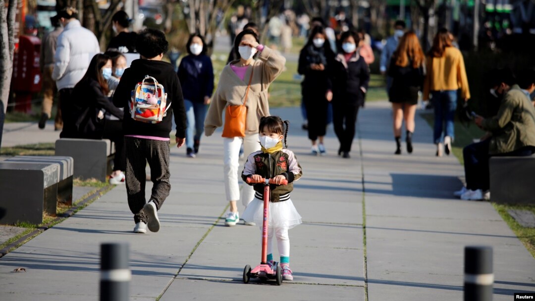 A girl wearing a protective face mask to prevent contracting the coronavirus disease (COVID-19) rides a toy kick scooter at a park in Seoul, South Korea, April 3, 2020. REUTERS/Heo Ran