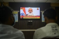 FILE - Journalists watch as India's Prime Minister Narendra Modi addresses the nation, at a journalist club in Siliguri, India, Oct. 20, 2020.