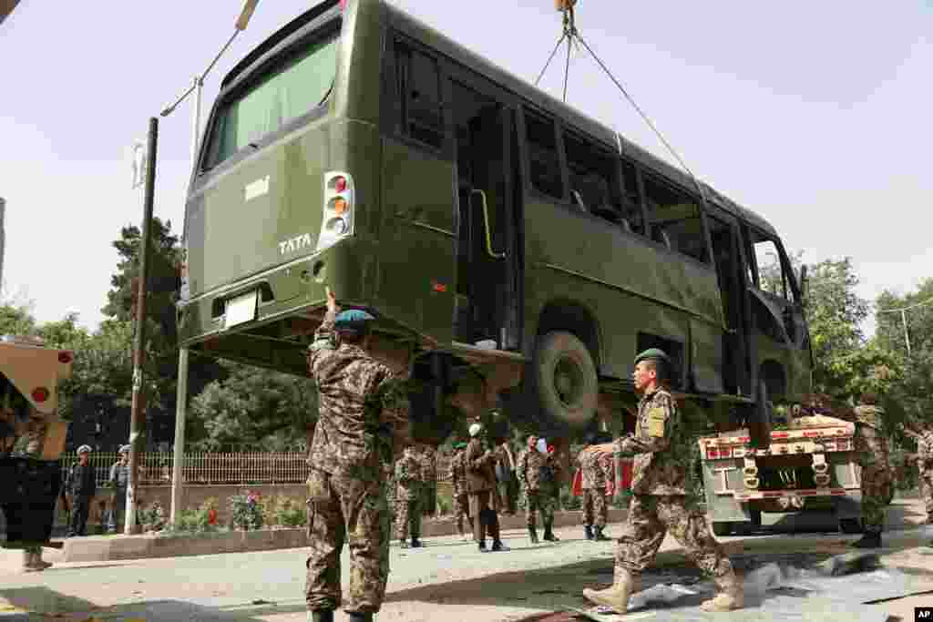 Afghan National Army soldiers prepare to remove a destroyed military bus after a suicide attack in Kabul, June 2, 2014.