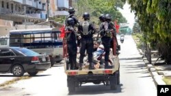 Des policiers emmènent un homme arrêté, à l'arrière d'un pick-up à Zanzibar, Tanzanie, 26 octobre 2015.