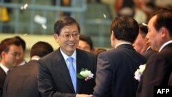South Korean Prime Minister Kim Hwang-Sik (C) shakes hands with guests during a launch ceremony in Sejong City, south of Seoul, July 2, 2012.
