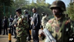 Kenyan security forces line up behind Interior Minister Joseph Ole Lenku during press conference near Westgate Mall, Nairobi, Sept. 25, 2013.