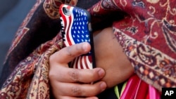 Une femme tient un téléphone portable avec une coque du drapeau des Etats-Unis, le vendredi 4 décembre 2015. (AP Photo / Jacquelyn Martin)