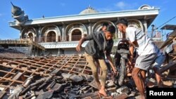 Warga setempat menyelamatkan barang-barang dari reruntuhan rumah dekat sebuah masjid di Gunungsari, Lombok Barat (foto: ilustrasi). 