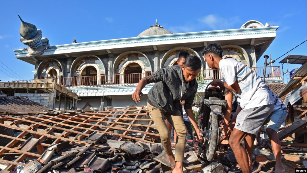 Warga sedang mengambil sepeda motor dari rumah yang rusak akibat gempa kuat di Gunungsari, Lombok Barat, 6 Agustus 2018. (Antara Foto/Ahmad Subaidi/ via Reuters)
