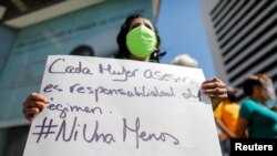 A woman holds a placard as Venezuelan human rights activists protest to demand the release of 17 women they consider political prisoners, as well as to demand punishment for perpetrators of femicide, in Caracas, Venezuela, March 8, 2021.