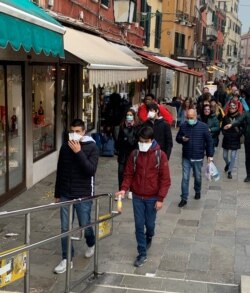 Tourists are wearing protective masks against coronavirus in Venice, Italy, Feb. 23, 2020. (S. Castelfranco/VOA)