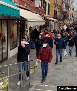 Tourists are wearing protective masks against coronavirus in Venice, Italy, Feb. 23, 2020. (S. Castelfranco/VOA)