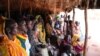 Refugees take shelter from the scorching sun as they wait to register at Yida refugee camp in South Sudan's Upper Nile, August 2012. (VOA - H. McNeish)