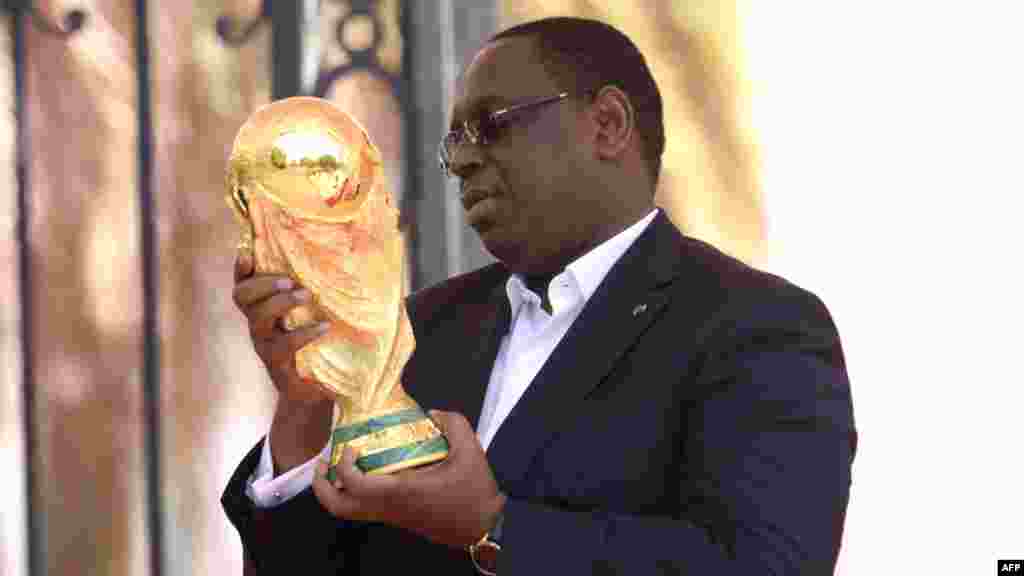 Le président du Sénégal, Macky Sall, avec le trophée de la Coupe du Monde de la FIFA, au Sénégal, le 11 mars 2018.