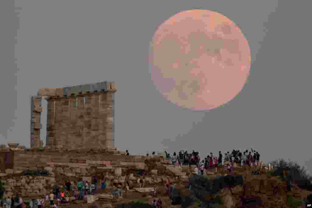 The moon rises behind the columns of the ancient marble Temple of Poseidon at Cape Sounion, about 70 Km (45 miles) south of Athens, Greece, Aug. 2, 2020.