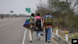 FILE - Venezuelan migrants walk to Lima along the shoulder of the Pan-American Highway near Tumbes, Peru, Aug. 26, 2018. 