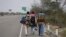 FILE - Venezuelan migrants walk to Lima along the shoulder of the Pan-American Highway near Tumbes, Peru, Aug. 26, 2018. 