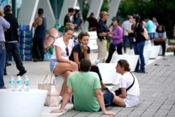 People wait for news at a family reunification center, after a wing of a 12-story beachfront condo building collapsed, June 24, 2021, in the Surfside area of Miami.