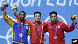 Kim Un Guk peraih medali emas dari Korea Utara (tengah) berpose bersama peraih perak, Oscar Mosquera dari Kolombia (kiri) dan peraih perunggu Eko Yuli Irawan dari Indonesia (kanan) usai penyerahan medali (30/7). 