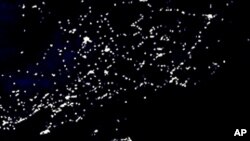 This undated composite satellite image produced and released by NASA shows the night lights of North and South Korea, center, with Japan at right and China at left. The contrast between North and South is about to change for a small corner of the North.