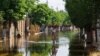 Una mujer camina por una calle después de que la inundación retrocedieran tras el colapso de la represa Nova Kakhovka en el curso del conflicto entre Rusia y Ucrania, en la ciudad de Hola Prystan en la región de Kherson, Ucrania controlada por Rusia, el 16 de junio de 2023.