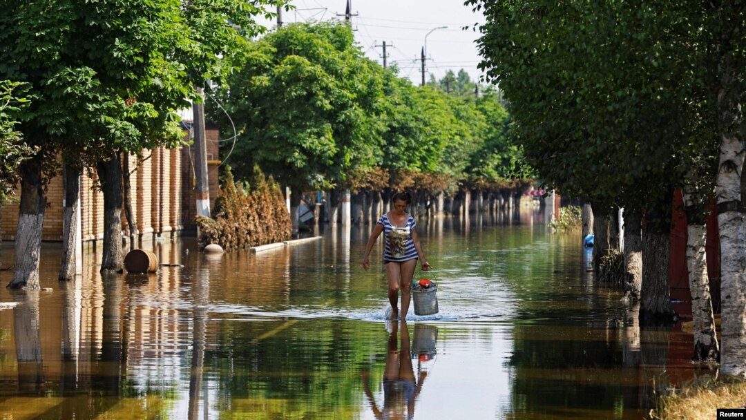 Una mujer camina por una calle después de que la inundación retrocedieran tras el colapso de la represa Nova Kakhovka en el curso del conflicto entre Rusia y Ucrania, en la ciudad de Hola Prystan en la región de Kherson, Ucrania controlada por Rusia, el 16 de junio de 2023.