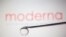 Moderna logo is reflected in a drop on a syringe needle