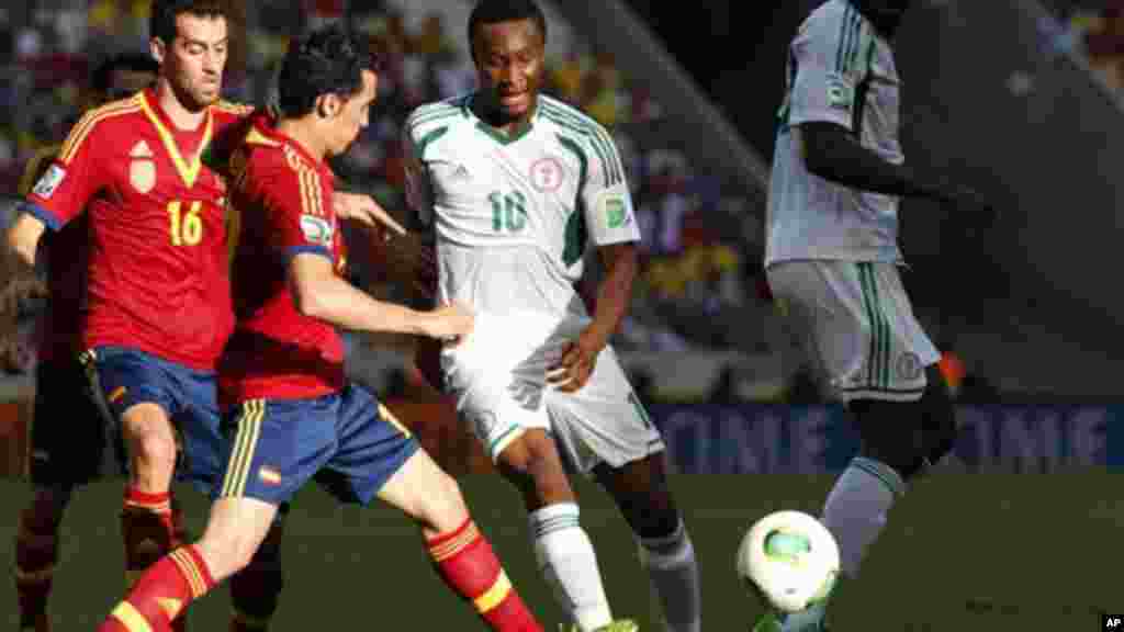 Nigeria's Emeka Eze, right, is challenged by Spain's Sergio Busquets, left, and Alvaro Arbeloa.
